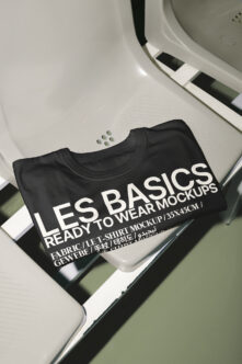 Black folded t-shirt mockup with white text on neutral background with color swatches