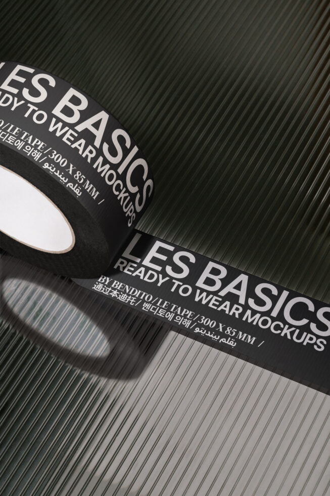 Black branded tape mockup reading Les Basics Ready to Wear on a textured surface. Ideal for packaging design. Digital asset for designers on Marketplace.