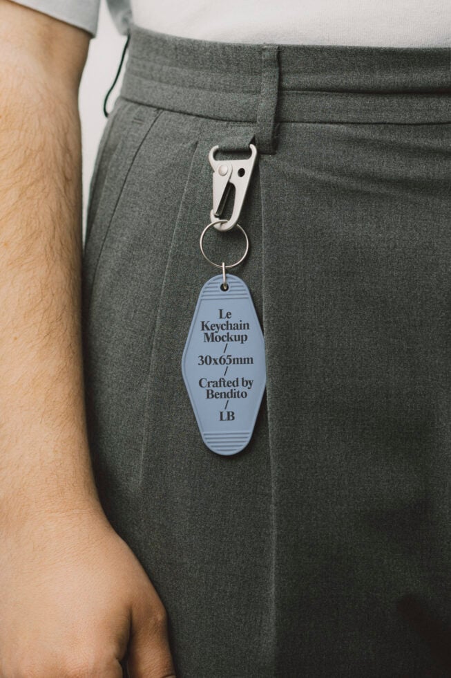 Mockup of a keychain attached to gray trousers, featuring text details. Ideal for designers seeking realistic keychain mockups. Digital asset marketplace.
