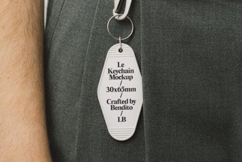 Keychain mockup with dimensions 30x65mm attached to a fabric surface. Ideal for designers. Keywords mockup, keychain, designer asset, template.