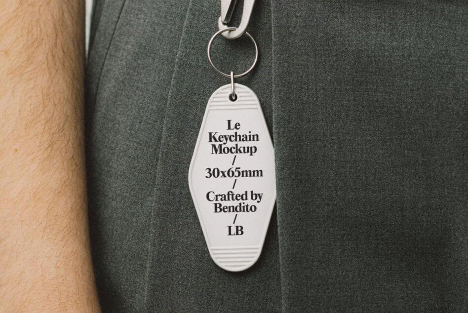 Close up of white oval keychain with retro ridged texture hanging from belt loop