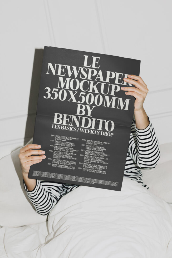 Person in striped shirt holding dark newspaper mockup 350x500mm