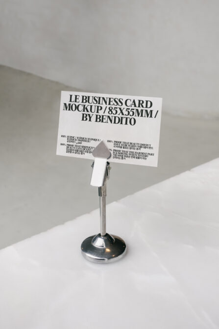 White business card mockup in metal stand with multilingual typography on minimal background
