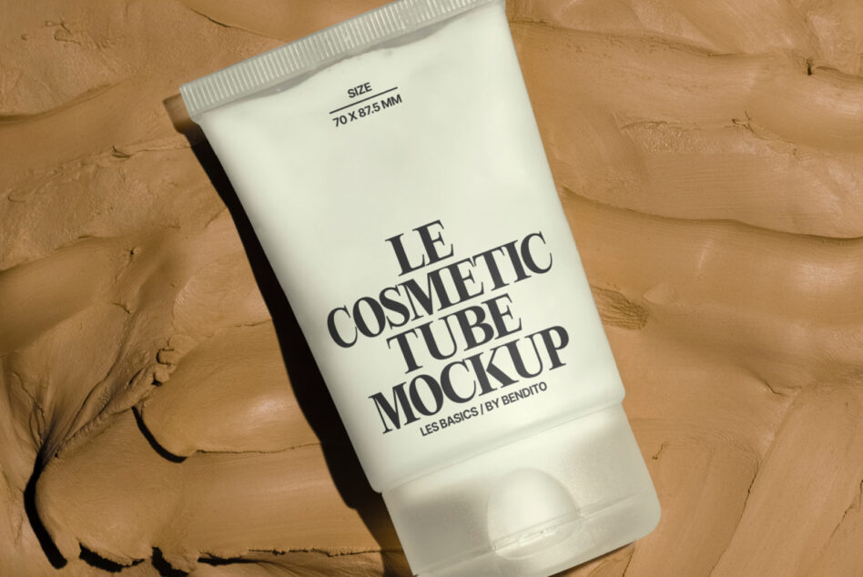 Cream cosmetic tube with minimalist label on textured tan background