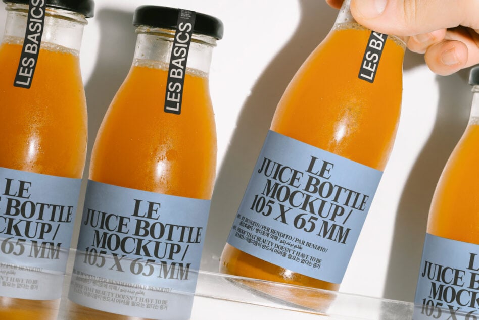 Juice bottles with blue label bands held up showing front label design