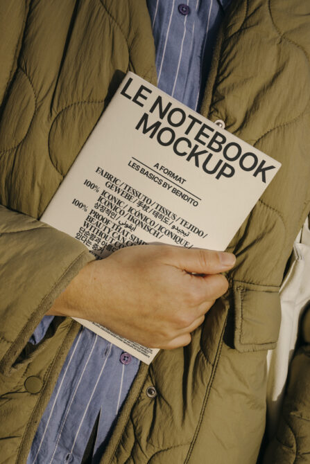 Cream notebook label tag on khaki puffer jacket with striped blue shirt