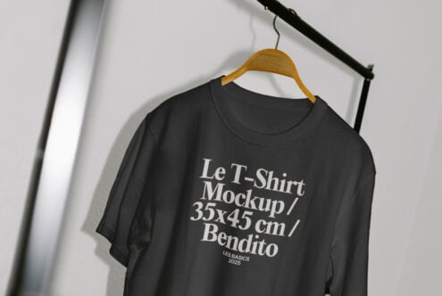 Black T-shirt mockup on hanger featuring white text for design display. Perfect for apparel designers. Keywords: T-shirt mockup, apparel design.