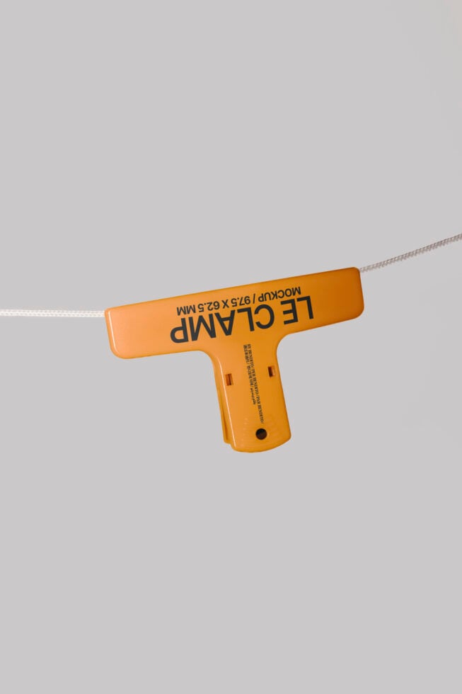 Orange clamp mockup hanging on rope isolated on gray background showcasing design utility and presentation for designers and product displays.