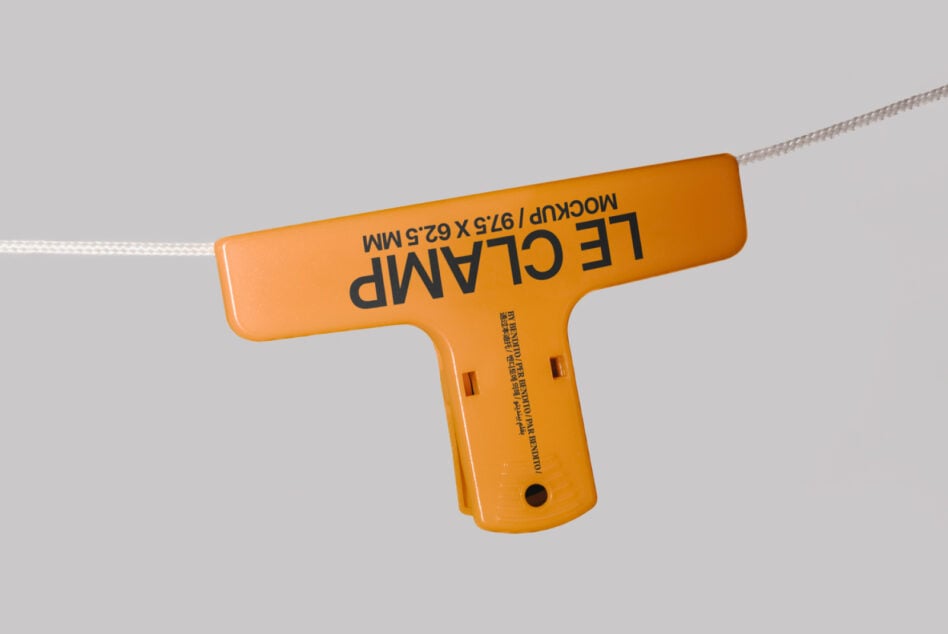 Bright orange T-shaped clothing tag swinging from white string on plain background