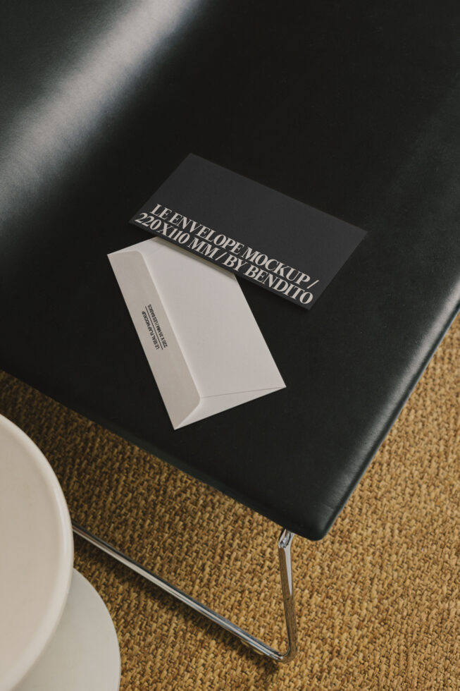 Envelope mockup and card on black leather surface and beige rug ideal for designers seeking high-quality stationery graphics and template resources.