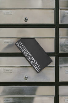 Black business card mockup tilted on metal mailbox with office numbers