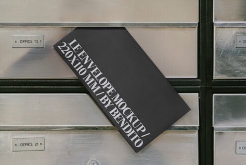 Envelope mockup with bold text design leaning on a metal mailbox. Ideal for graphic designers seeking sleek and modern stationery presentations.