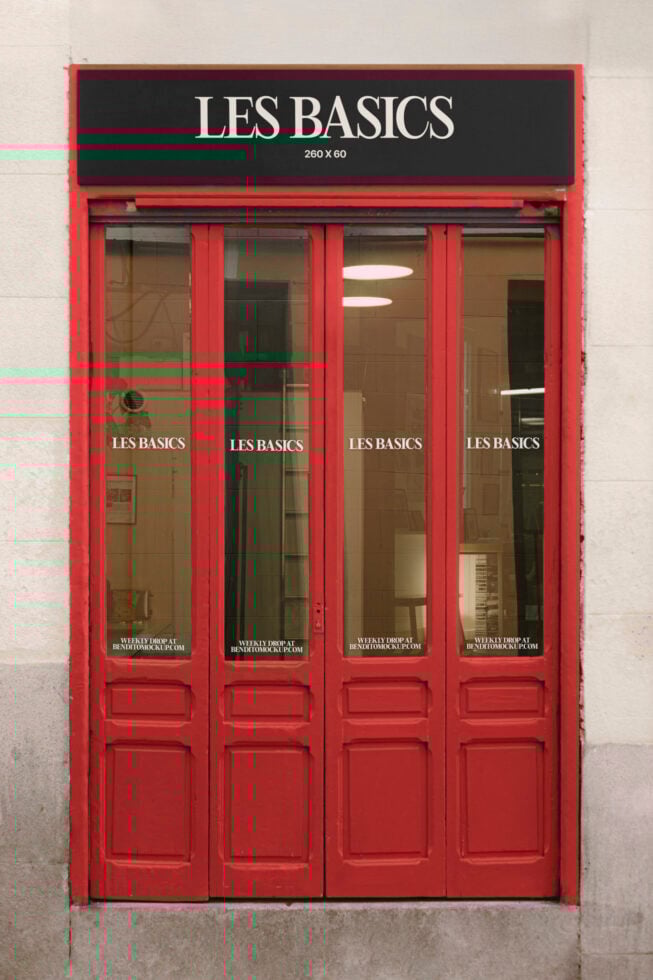 Shop facade mockup featuring red doors and black sign with text Les Basics ideal for branding. Perfect for designers seeking realistic storefront displays.