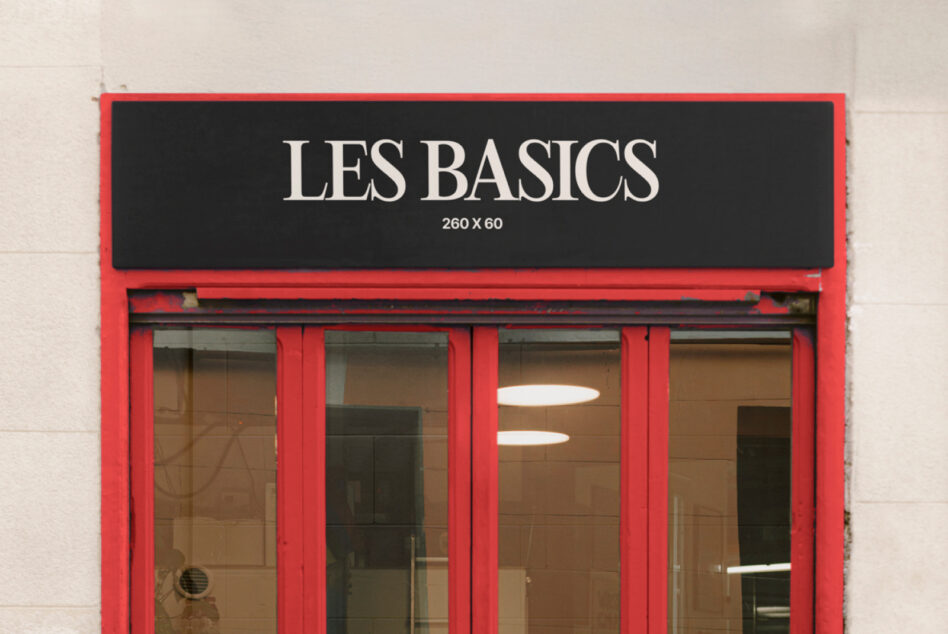 Red shop facade close up showing Les Basics sign above glass storefront windows