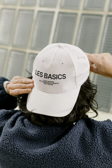 Off white baseball cap with Les Basics embroidered on front, worn by person