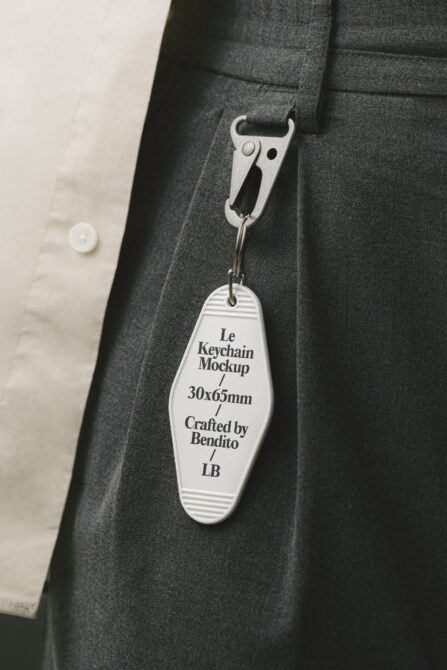 Motel keychain tag hanging from carabiner on dark jacket pocket