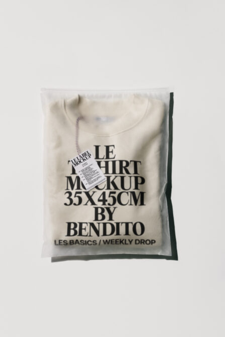 Cream colored crewneck tee in plastic packaging with printed label mockup
