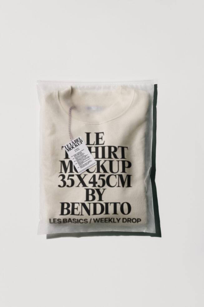 Cream colored crewneck tee in plastic packaging with printed label mockup