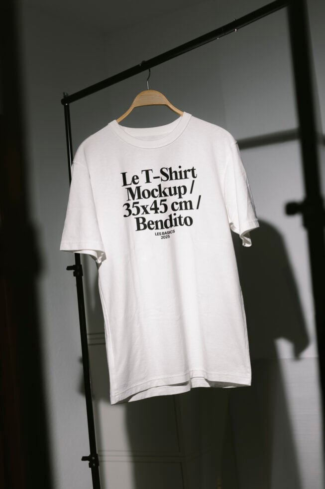 White T-shirt mockup on hanger in well-lit space with bold typography. Perfect for designers. Keywords: fashion, apparel, mockup, design asset.