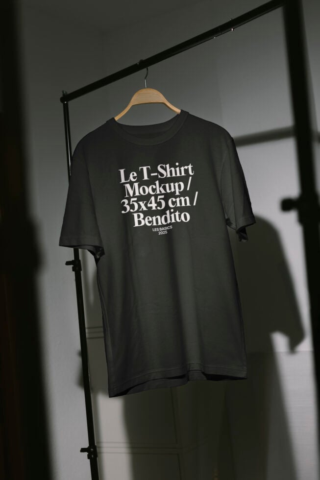 T-shirt mockup hanging on a wooden hanger in a minimalist setting suitable for apparel design presentations digital assets mockups templates designers.