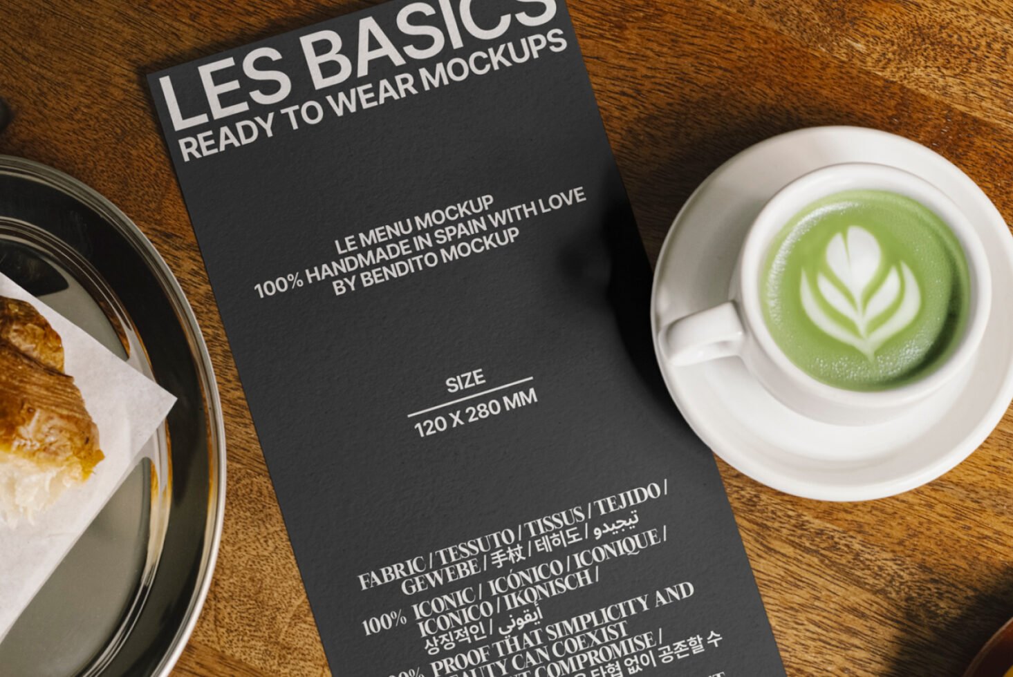 Menu mockup on wood table, featuring a cup of matcha latte and a croissant, ideal for showcasing design projects. Keywords: mockup, design, template.