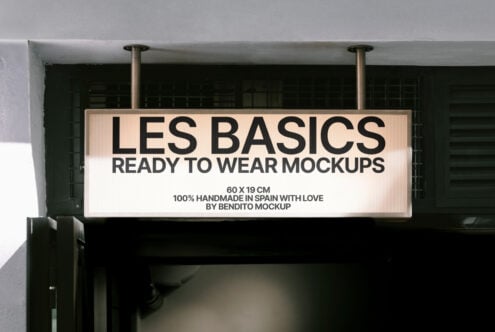 Indoor signage mockup with bold black text Les Basics Ready to Wear Mockups on a rectangular lightbox. Design asset for branding and retail presentations.