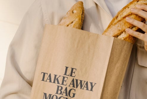 Mockup of a paper bag with baguettes, perfect for branding designs. Keywords: paper bag mockup, bakery branding, packaging design, product presentation.