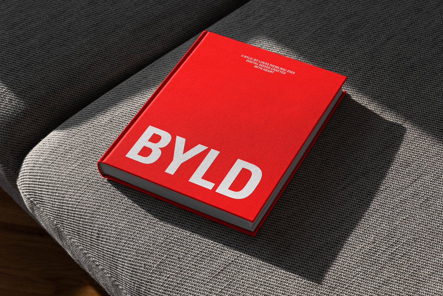 Red hardcover book mockup on a textured grey fabric surface for design presentations branding marketing realistic shadows minimalist style typography
