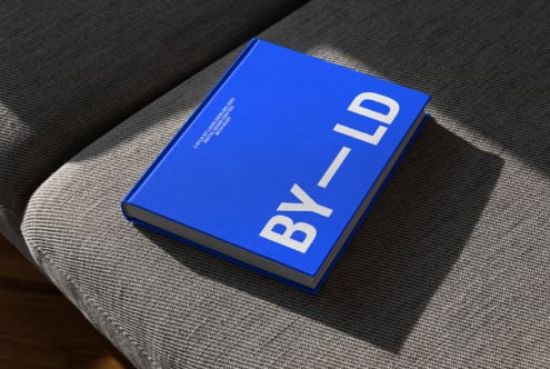 Blue hardcover book on grey fabric surface sunlight angled Mockup asset for graphic designers sleek minimal modern text typography professional layout