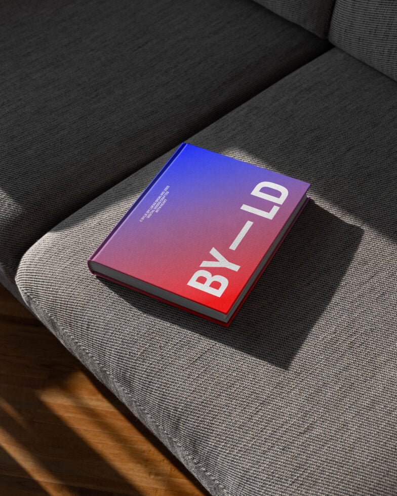 Modern book mockup featuring a colorful cover with gradient design on a gray textured sofa perfect for showcasing graphic design templates for designers.