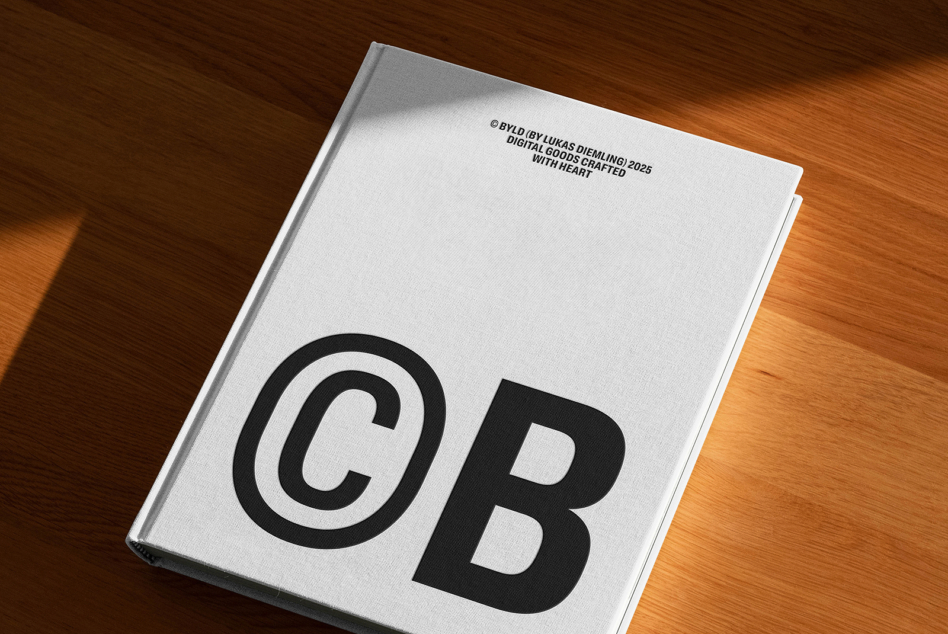 Cream hardcover book with large black CB letters on wooden desk