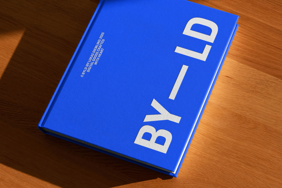 Blue hardcover book with white BY_LD typography rotated on fabric