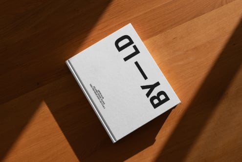 Elegant book mockup on wooden surface with natural light shadows; ideal for showcasing design projects; keywords: book, mockup, design, shadow, wood.