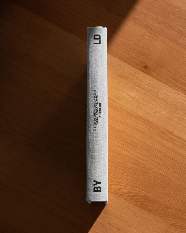 Hardcover book spine with minimalist design on wood surface suitable for mockups templates. Ideal for showcasing cover graphics in creative projects.