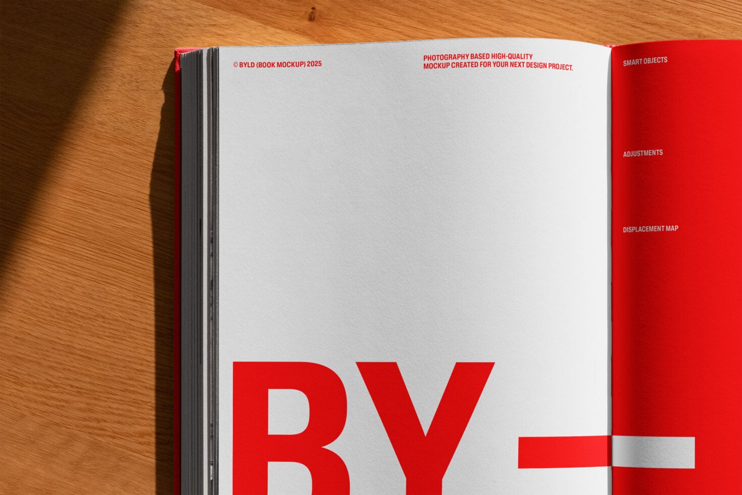 Open hardcover book showing left page with red spine on wooden floor