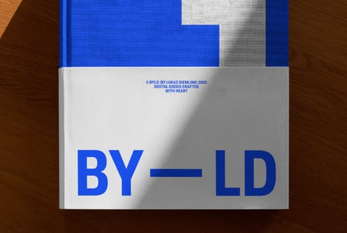 Blue hardcover book with geometric white cutout design on wood surface