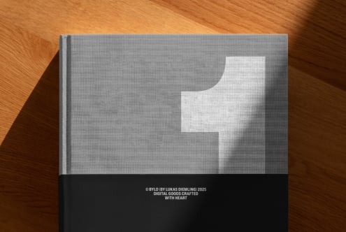 Minimalist hardcover book with white abstract shape on wood table