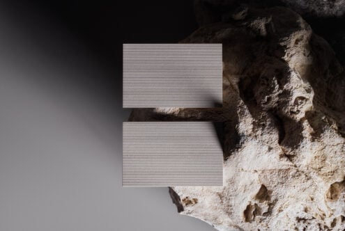 Business card mockup on textured rock background with natural lighting shadows. Ideal for showcasing card designs. Perfect for designers marketing.