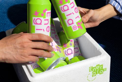 Hands holding neon green energy drink cans with bold pink text design in a white cooler. Modern beverage packaging mockup for designers, vibrant branding.