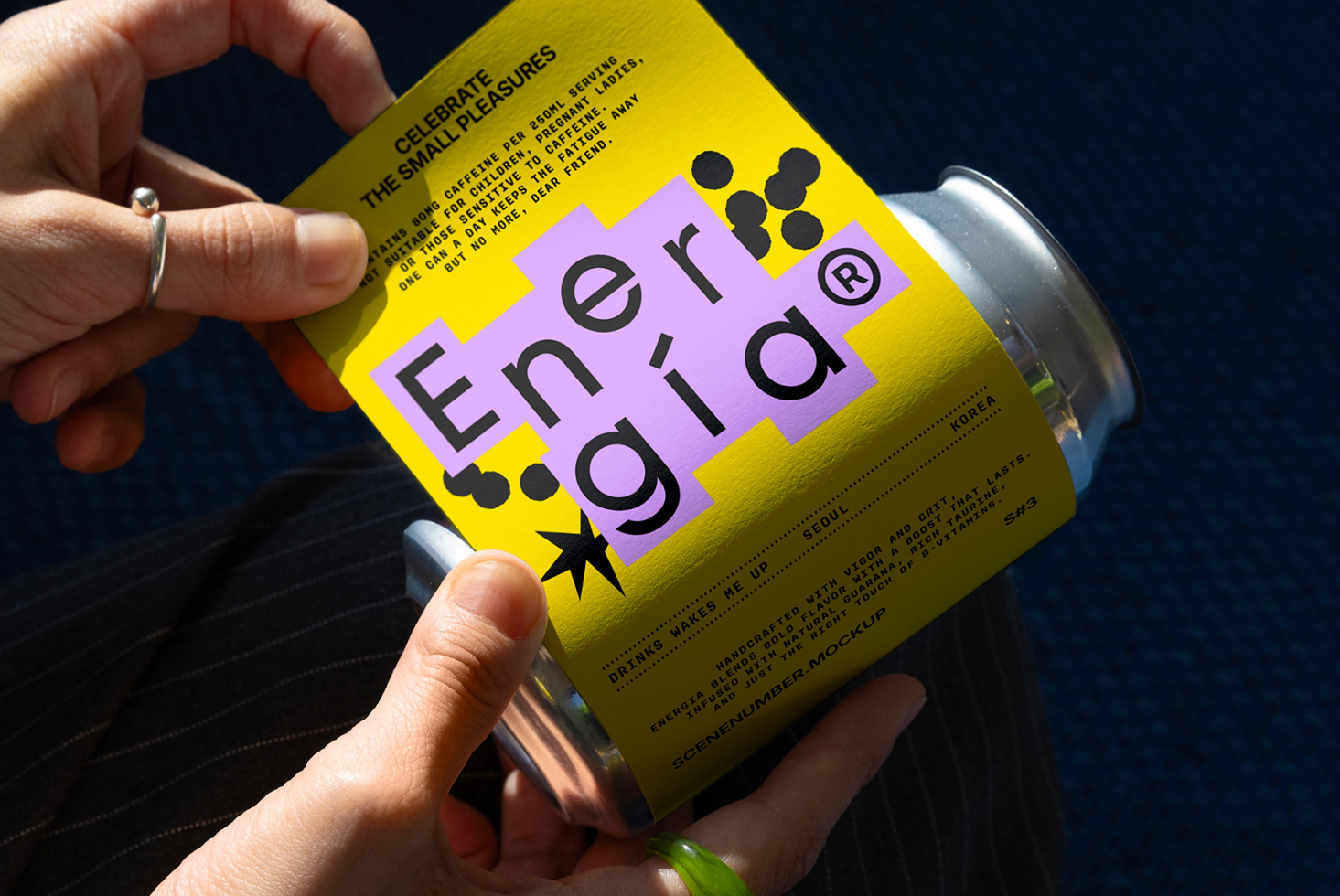 Person holding a vibrant yellow can mockup with purple and black typography design. Ideal for graphic designers seeking creative packaging inspiration.