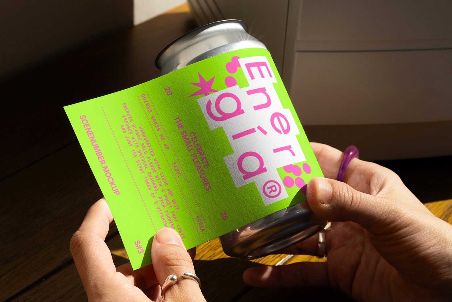 Hand holding bright green beverage can label mockup on sunny wooden surface ideal for designers creating packaging graphics branding templates.
