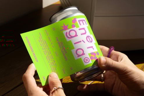 Hand holding bright green beverage can label mockup on sunny wooden surface ideal for designers creating packaging graphics branding templates.