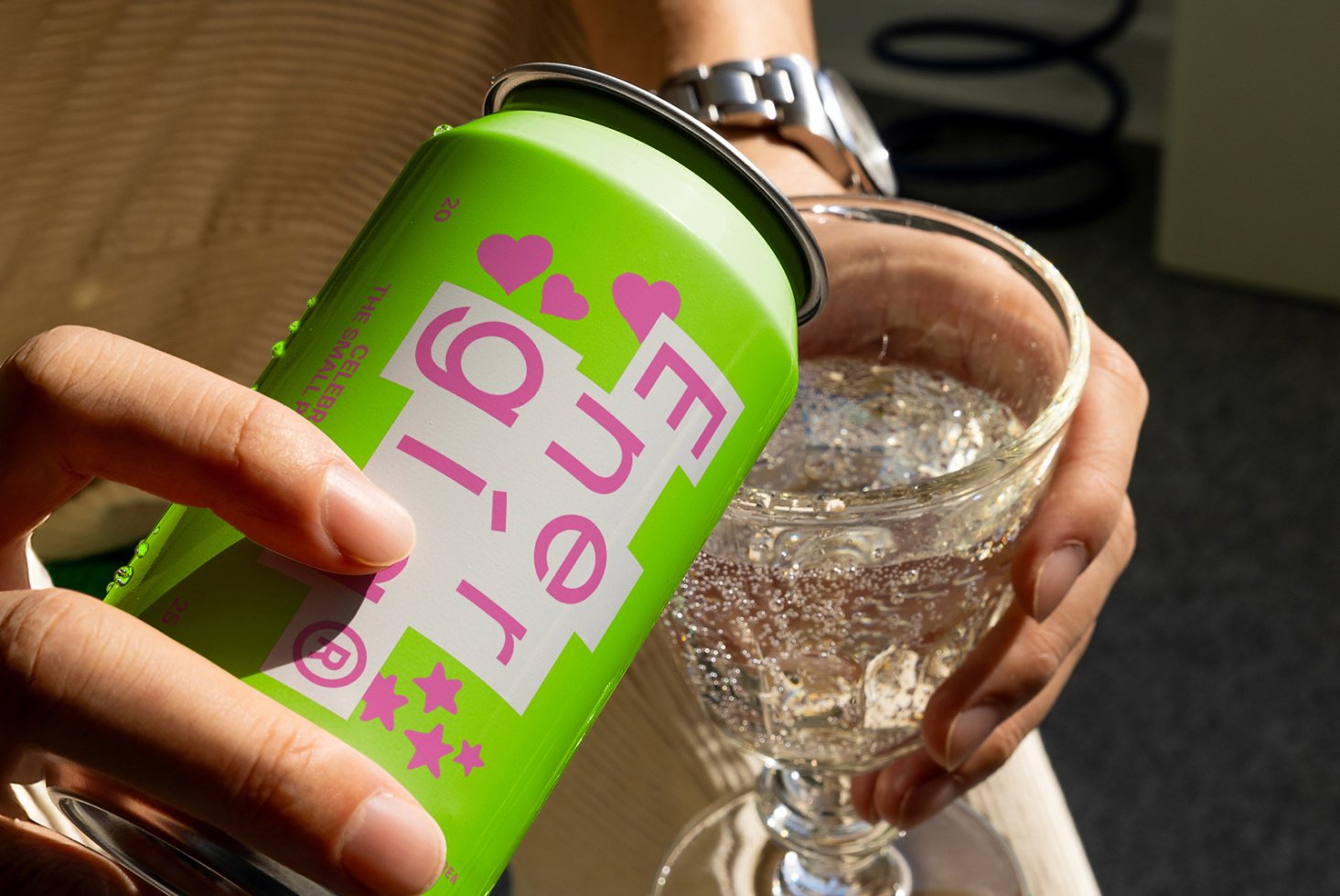 Vibrant energy drink can with green design being poured into glass emphasizing refreshing beverage mockup ideal for designers searching for graphics resources.