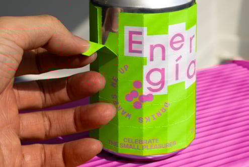 Hand peeling a vibrant lime green and pink can label, showcasing modern typography. Ideal for designers seeking beverage packaging mockup inspiration.