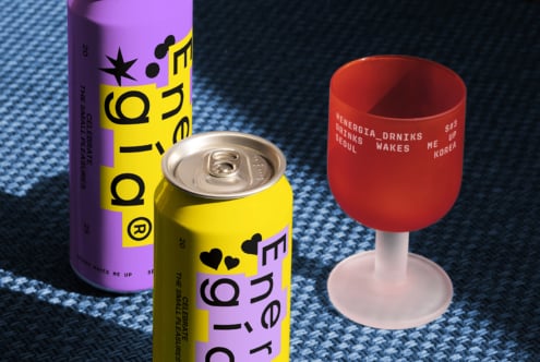 Colorful energy drink cans and a branded cup on a blue textured surface. Vibrant packaging design for beverage mockup. Ideal for graphic designers.