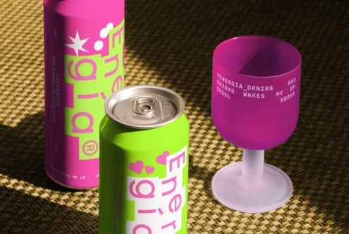 Colorful energy drink cans and cup packaging mockup on textured surface, vibrant pink and green design for creative branding applications.
