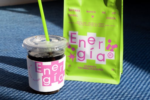 Coffee cup and package with vibrant neon green and pink branding design on blue surface perfect for mockups designers seeking bold packaging graphics