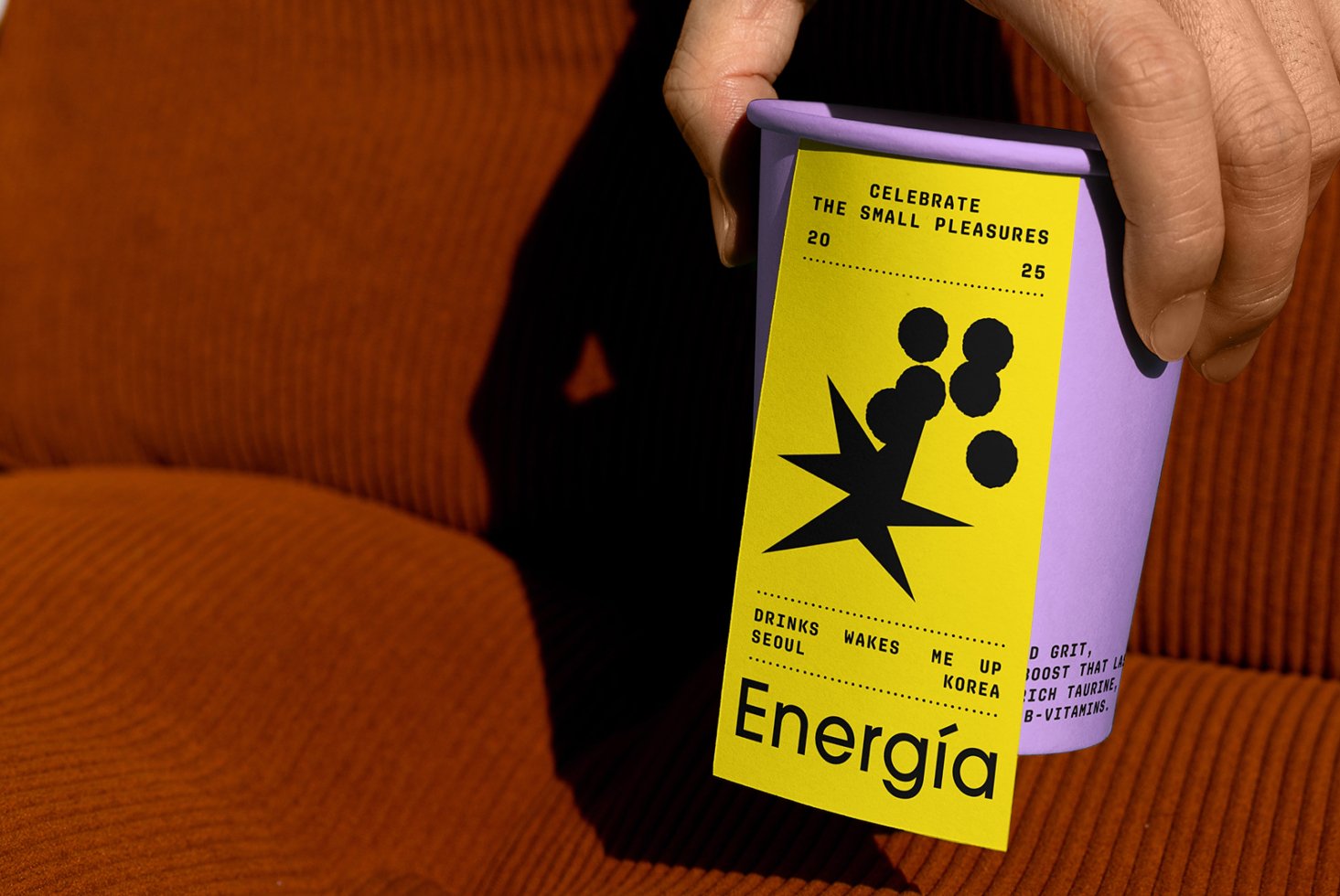 Purple coffee cup with vibrant energy drink label design featuring bold black typography and graphics ideal for mockup showcase or graphic projects.