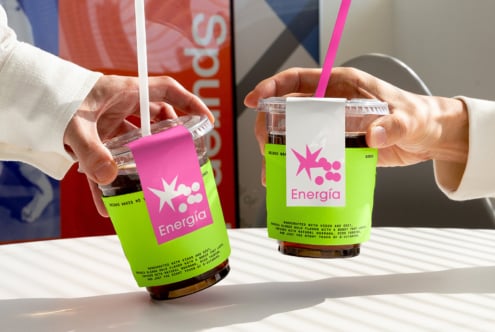 Two hands holding vibrant drinks with bold pink and green branding. Perfect graphic design asset for packaging mockups or branding templates.