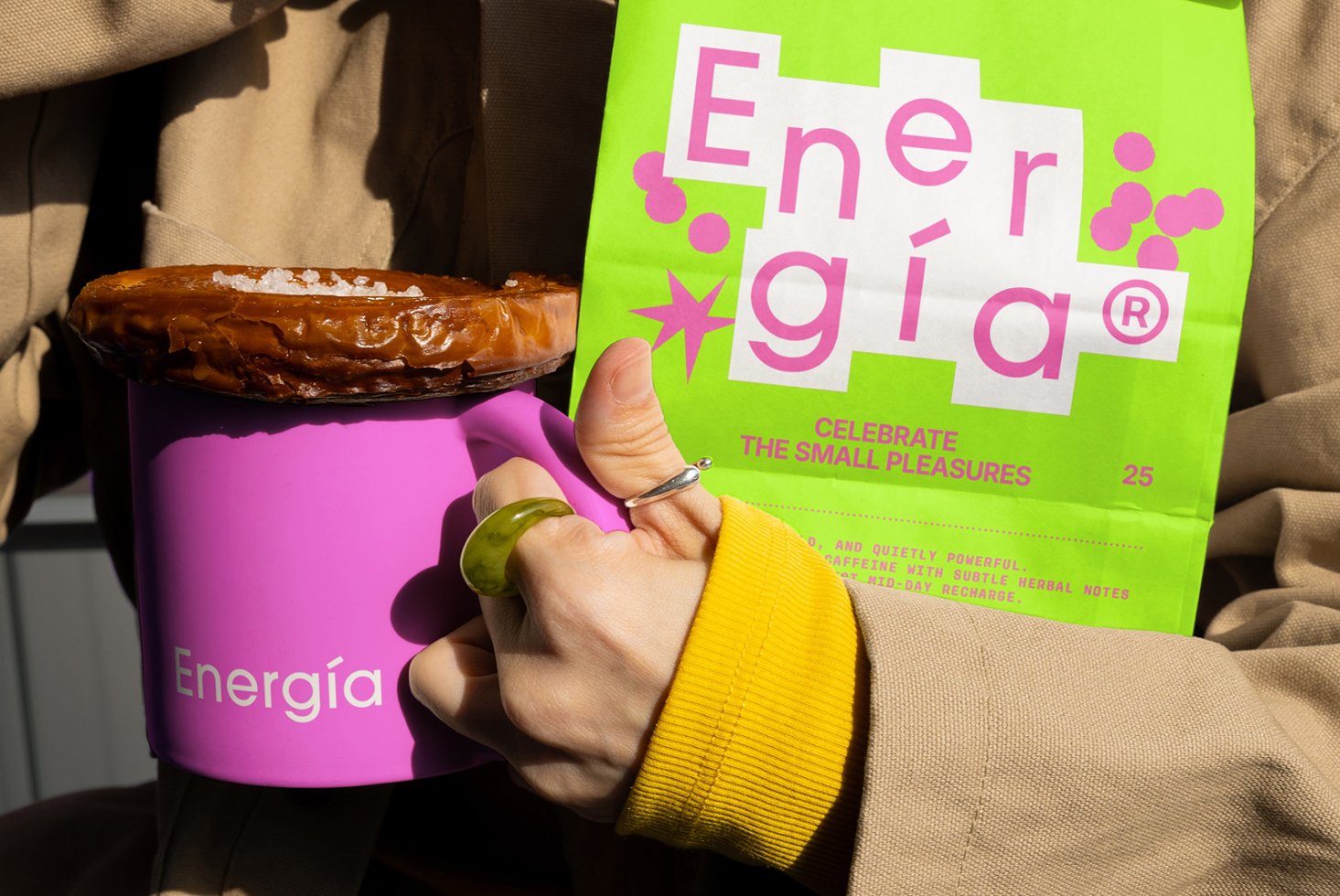 Colorful branding mockup featuring a pink mug and green packaging with the word Energía. Ideal for showcasing logo designs, product templates.